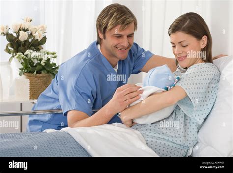 Parents smiling at newborn baby in hospital Stock Photo - Alamy