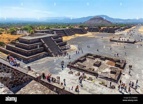 Tourists climbing the Moon Pyramid with Sun Pyramid and Alley of the ...