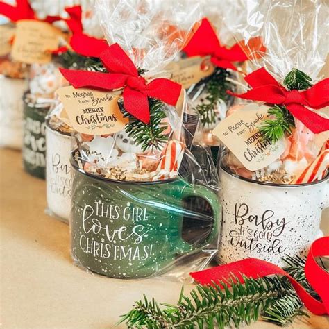 three mugs filled with christmas treats on top of a table