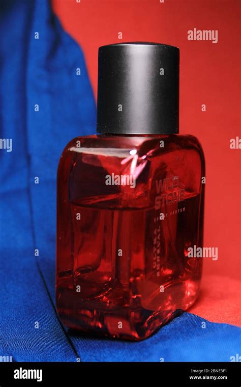 Red color men perfume bottle isolated on blue and red background with ...