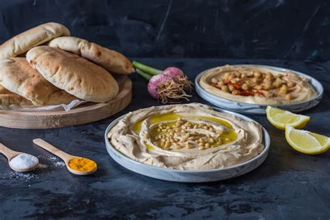 Premium Photo | Plates of hummus with pita bread on black background