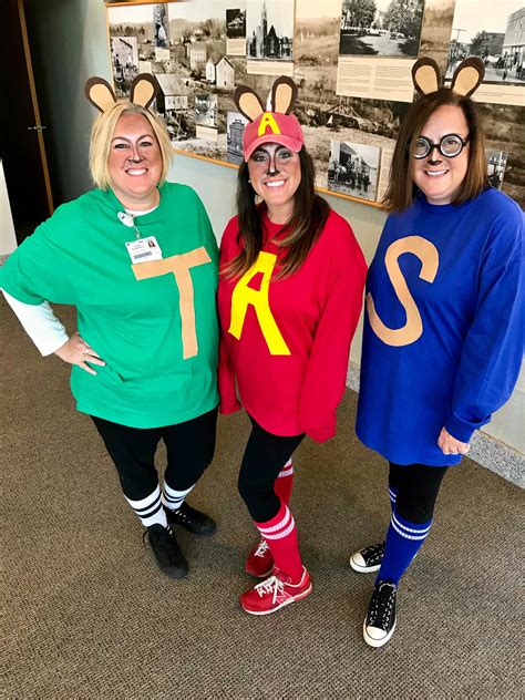 three women dressed up in costumes standing next to each other on the ...