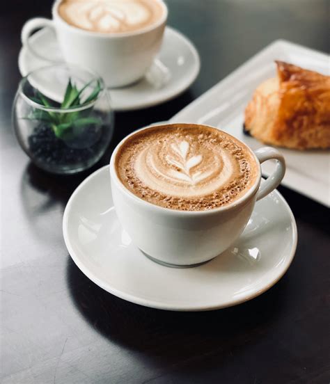 Cup of delicious coffee with froth on breakfast in cafeteria · Free Stock Photo