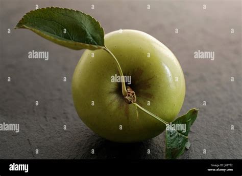 a green apple with leaves Stock Photo - Alamy