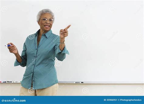 Teacher Pointing At Camera While Writing On Blackboard With Chalk ...