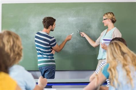 Premium Photo | Student and teacher pointing at blackboard