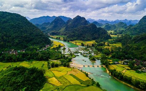 an aerial view of a river running through a valley surrounded by lush ...