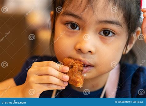 Asian Girl Eating Chicken. Child Eating a Chicken Nuggets Stock Photo ...