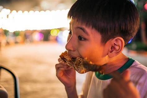 A Boy Eating Chicken Wings Stock Photo - Download Image Now - 8-9 Years ...