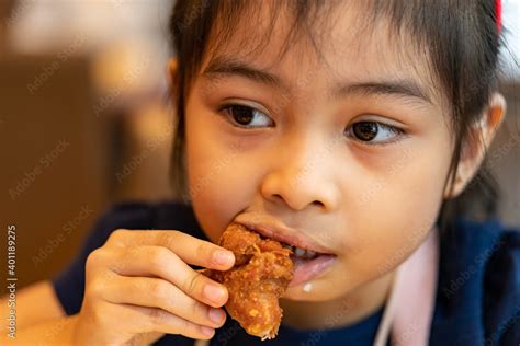 Asian girl Eating Chicken. child eating a chicken nuggets Stock Photo ...