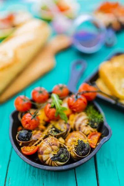 Baked escargot in butter with herbs and tomatoes Stock Photo by ...