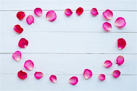 Premium Photo | Rose petals on white wooden background.