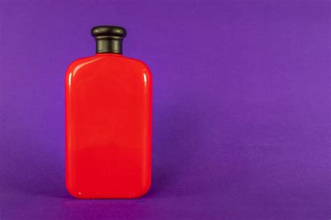 Premium Photo | Red bottle of man perfume on purple background