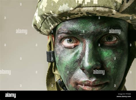 Soldier with face paint on grey background, closeup Stock Photo - Alamy