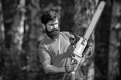 Premium Photo | Lumberjack worker with chainsaw in the forest ...