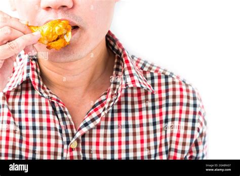 Man eating roasted chicken wings on white background Stock Photo - Alamy