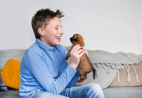 Niño jugando con un perro bebé. los niños juegan con cachorros en casa ...