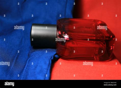 Red color men perfume bottle isolated on blue and red background with ...