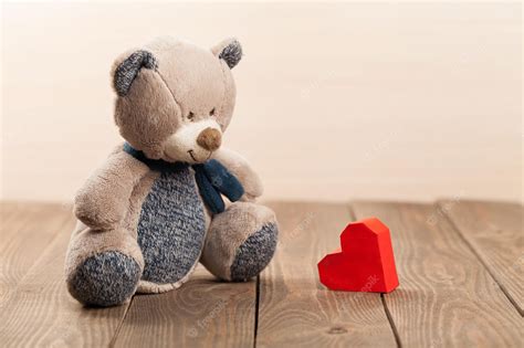 Premium Photo | Cute teddy bear with red heart on background