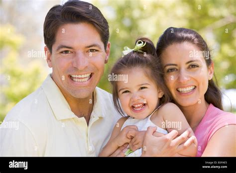 Family standing outdoors smiling Stock Photo - Alamy