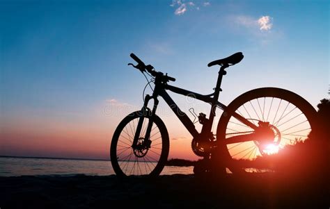 Silhouette of Bike Rider in Front of Sunset and Lake Stock Image ...