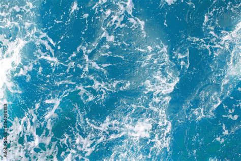 bright blue surface of ocean water with white foam, background, texture ...