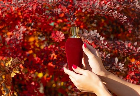 Premium Photo | Red perfume bottle in female hand presenting perfume ...