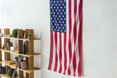 American flag hanging on wall inside living room - Stock Photo - Dissolve