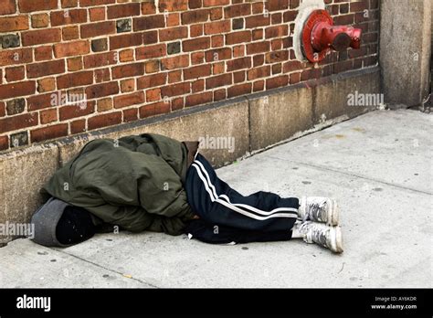 Homeless man tries to keep warm while sleeping on a New York city Stock ...