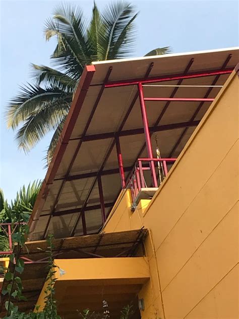 a yellow building with red railings and palm trees