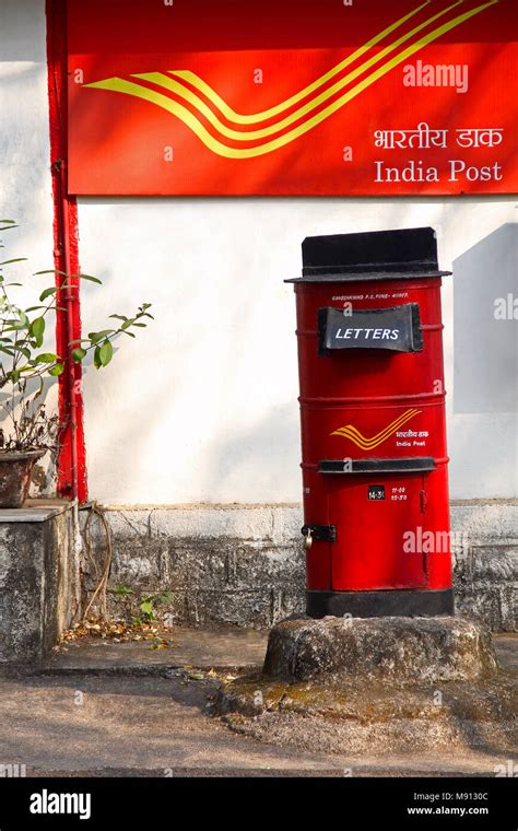 Red letter box with background of India Post, Pune University campus at ...