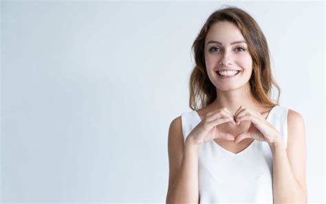 Smiling young woman making heart gesture with her hands • SeedTrust