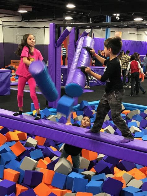 two children playing in an indoor play area with purple and orange ...