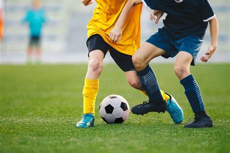 Closeup Of Soccer Player Running And Kicking Soccer Ball On Grass Lawn