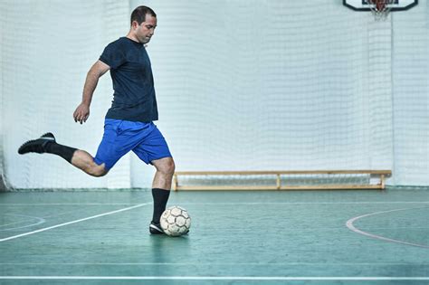 Man Playing Indoor Soccer Shooting The Ball Stock Photo