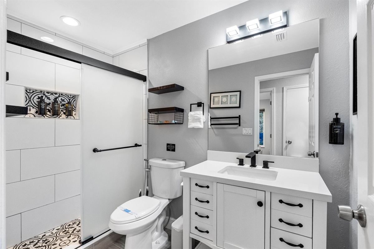 The black and white bathroom fixtures are tastefully integrated throughout the space, providing a sharp contrast that is both sophisticated and contemporary. 