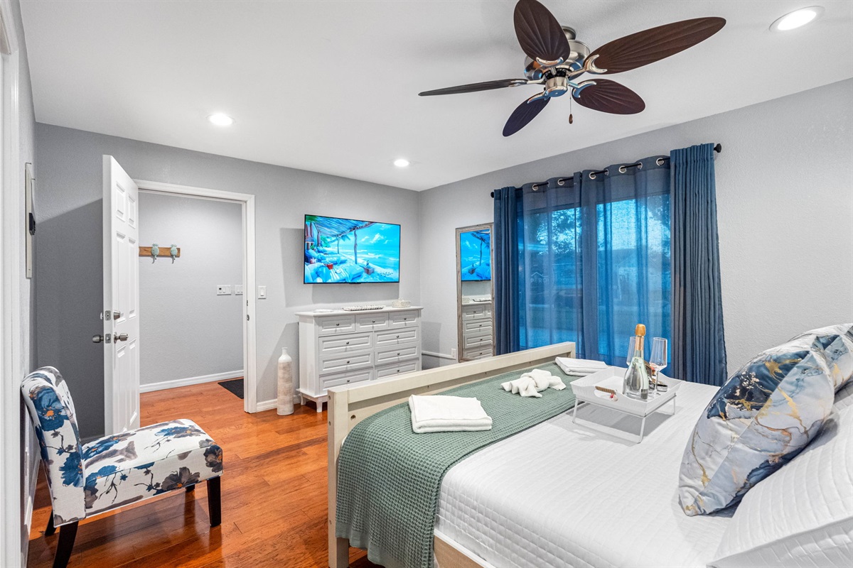 This king bedroom features a stunning aqua blue painted accent wall, which adds a refreshing pop of color and creates a serene, calming atmosphere.