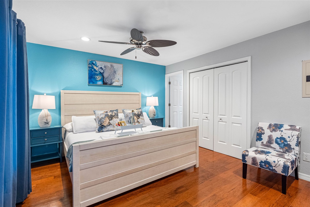 The room is further enhanced by a stunning aqua blue center wall that adds a refreshing pop of color and a serene ambiance.