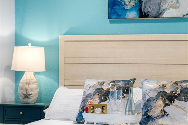 The bed frame is positioned against this eye-catching vibrant blue painted wall, creating a beautiful focal point and a cozy environment.