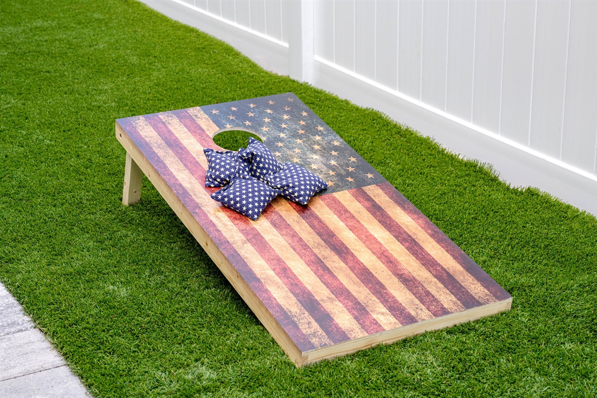 At the heart of this outdoor retreat is a well-loved cornhole game setup, a classic and engaging activity that brings a sense of excitement and friendly competition to the backyard.