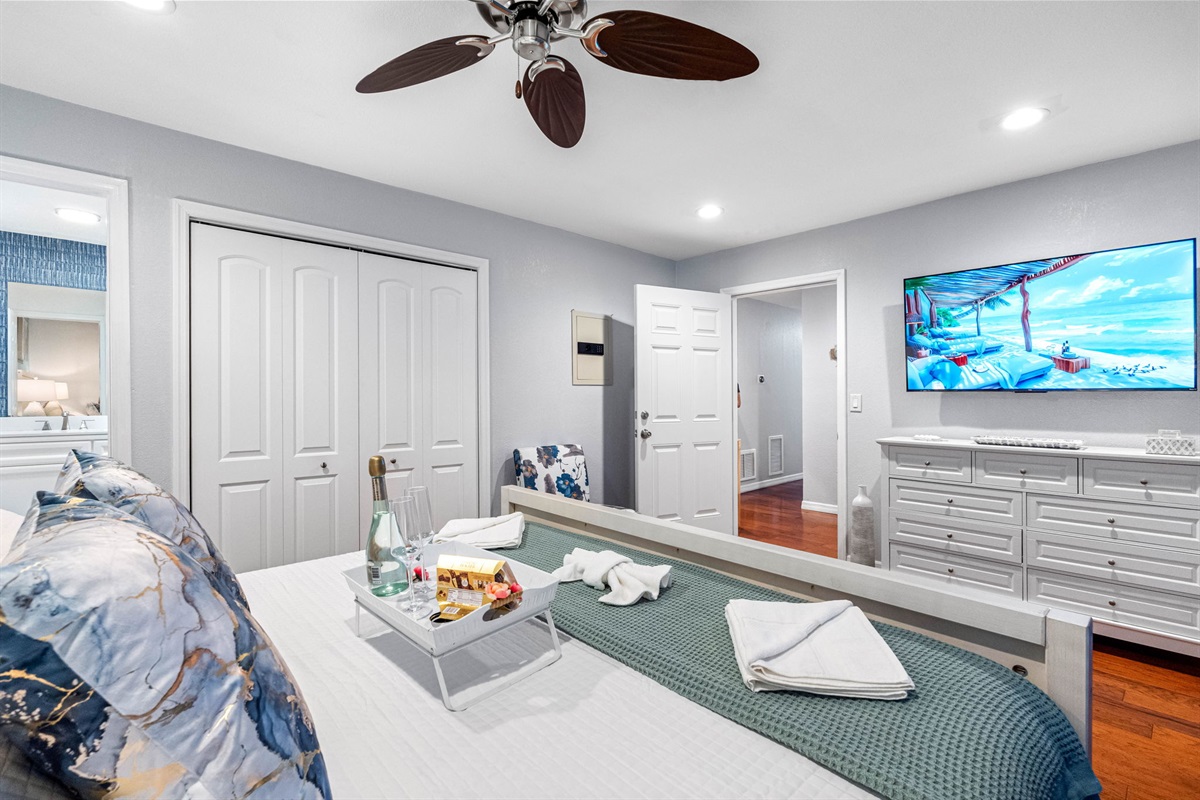 This spacious and inviting bedroom is designed with a luxurious king-size bed and elegantly furnished with stylish accents, including bedside tables with modern lamps, a spacious dresser, and ample closet space for all your belongings.