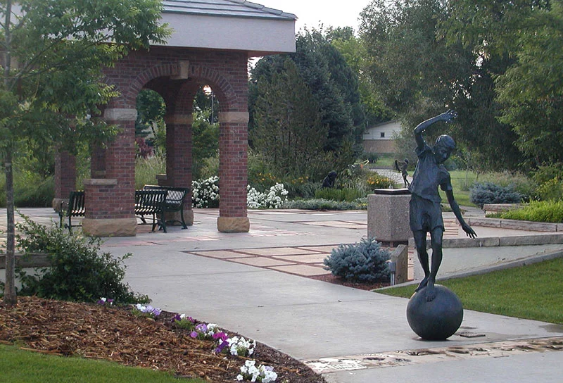 Pavilion and sculpture of girl balancing on a ball at Benson Scupture Garden, one of several great free things to do in northern Colorado.