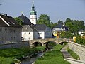 Brücke über die Schwesnitz, im Hintergrund die evangelische Kirche St. Jakobus mit Pfarrhaus