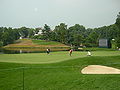 The new 10th hole of the Congressional Country Club's Blue Course during the Earl Woods Memorial Pro-Am prior to the 2007 AT&T National tournament. This replaced the old 18th hole, which had its tee in the foreground with the green across the water at the bottom left of the hill. Jason Gore's group is on the green.