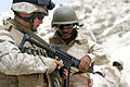 A Marine is coached by a Saidi Soldier.