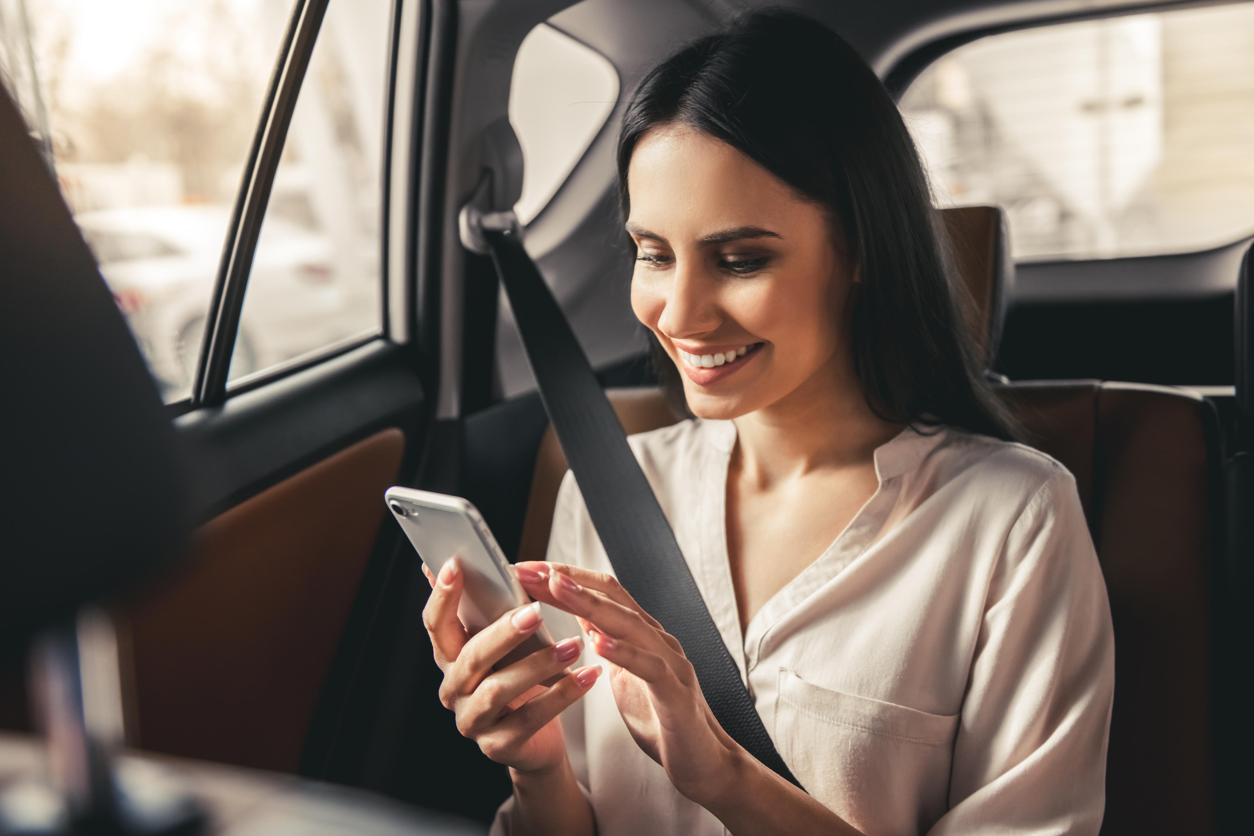 Arvato Systems_Presse_Woman on the phone in the car_Shutterstock_608853491