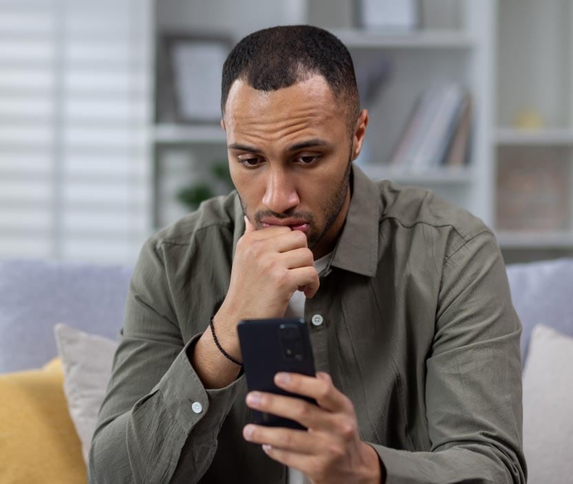 Person looking at a phone figuring out how to tell if their phone is tapped.