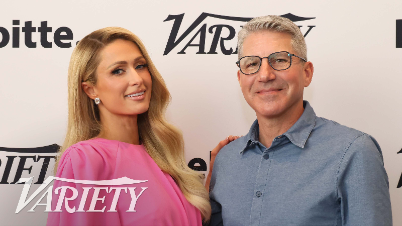 Paris Hilton and Bruce Gersh posing for a photo against a Variety backdrop at the Entertainment Marketing Summit