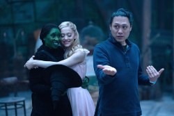 WICKED, from left: Cynthia Erivo, Ariana Grande, director Jon M. Chu, on set, 2024.  ph: Giles Keyte /© Universal Pictures / Courtesy Everett Collection