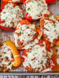 cheesy stuffed peppers in pan with plaid towel